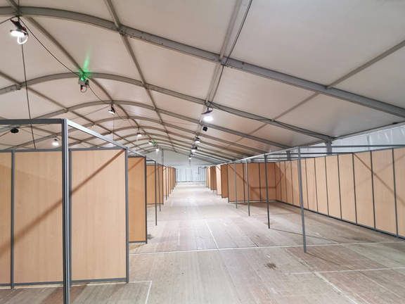 Hall d'exposition avec stands en cours de montage